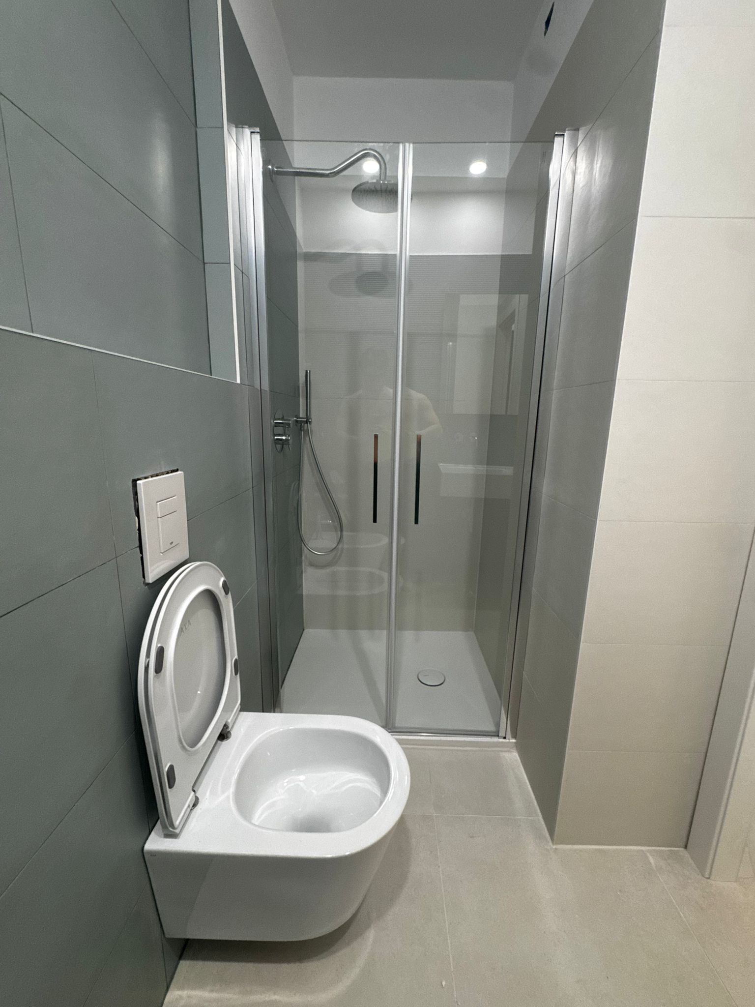 Private bathroom with shower and wall-hung sanitary fixtures