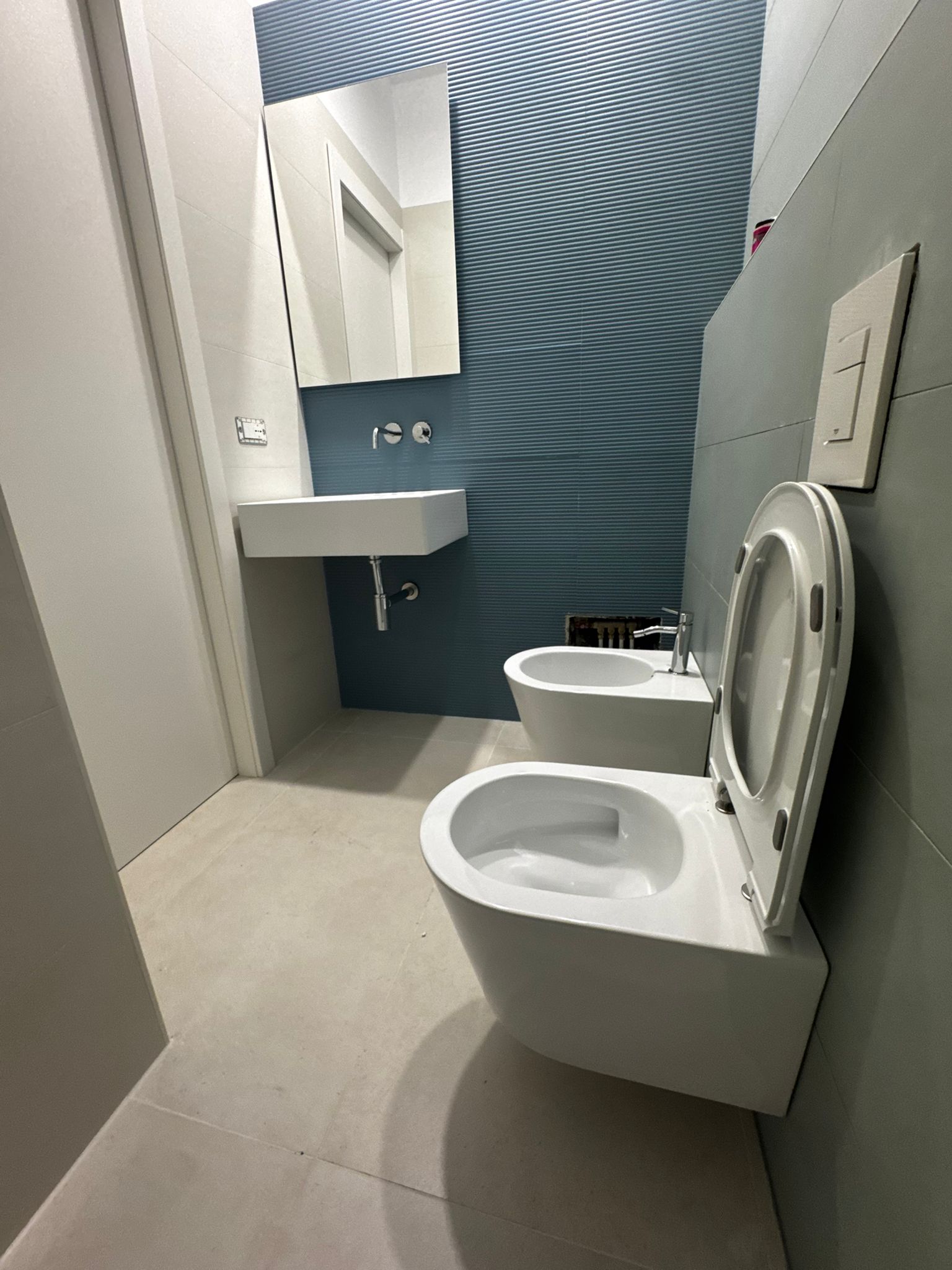 Private bathroom with sink, mirror and light wall tiles